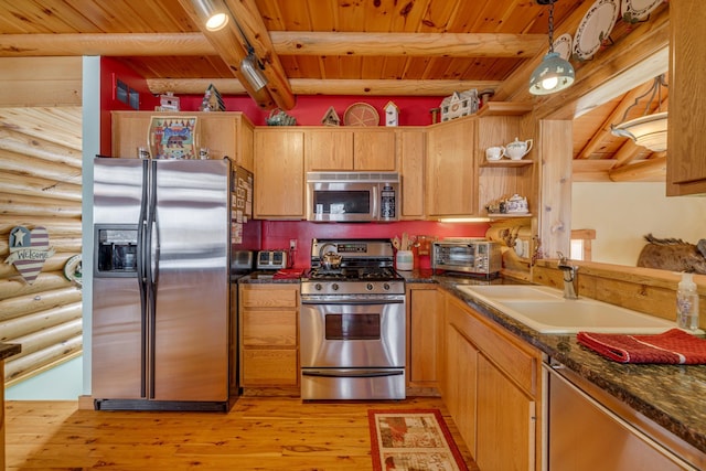 kitchen featuring dark countertops, wooden ceiling, beamed ceiling, stainless steel appliances, and a sink