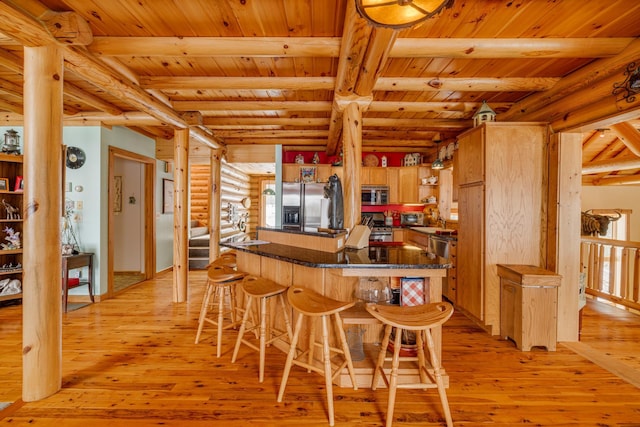 kitchen with appliances with stainless steel finishes, light wood-style floors, log walls, and open shelves