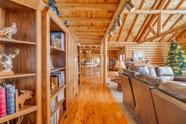 hallway with log walls, lofted ceiling with beams, wood ceiling, light carpet, and track lighting