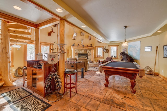 rec room with plenty of natural light, billiards, stone tile flooring, and a stone fireplace