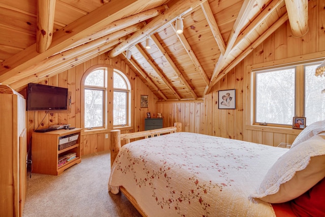 bedroom with lofted ceiling, rail lighting, wood walls, and light carpet