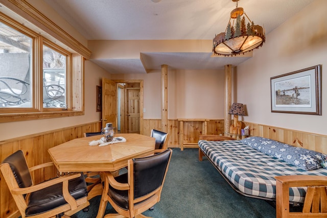 bedroom featuring carpet floors, a wainscoted wall, wood walls, and a textured ceiling