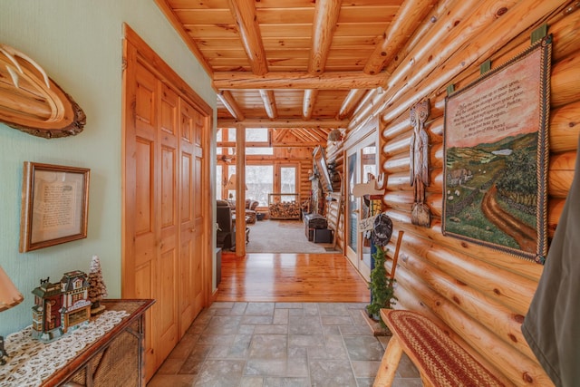 hallway with beamed ceiling, wooden ceiling, and stone finish floor