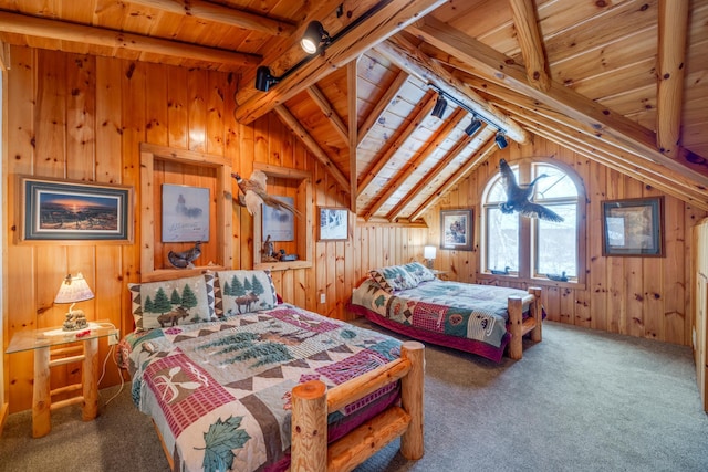 bedroom with carpet, rail lighting, lofted ceiling with beams, wood ceiling, and wood walls