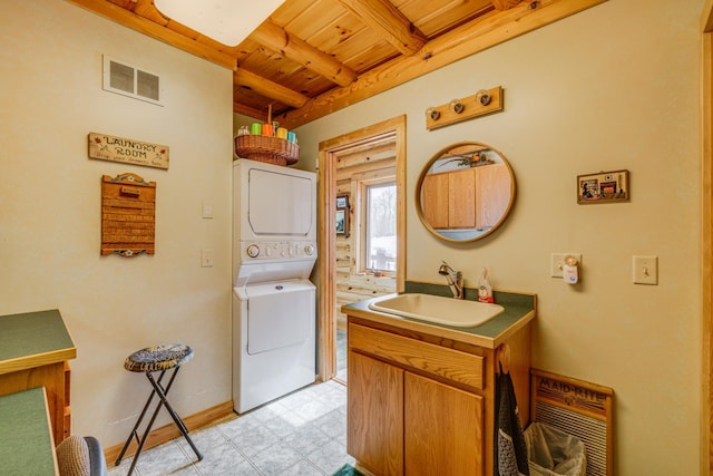 clothes washing area with laundry area, visible vents, stacked washer and clothes dryer, wooden ceiling, and a sink