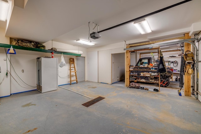 garage with a garage door opener and freestanding refrigerator