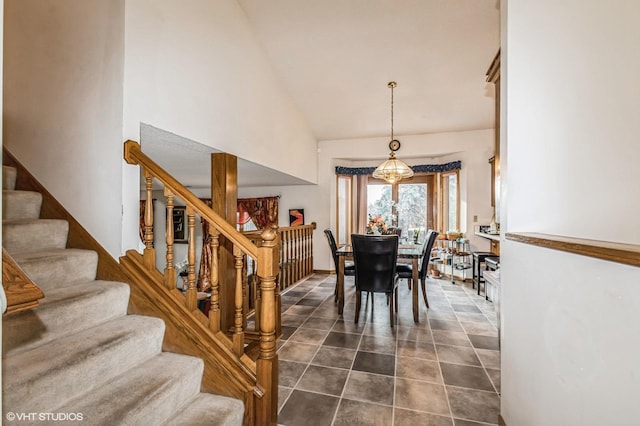 dining area with stairway, high vaulted ceiling, and dark tile patterned floors