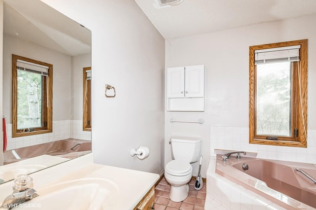 bathroom with toilet, a bath, vanity, and tile patterned flooring