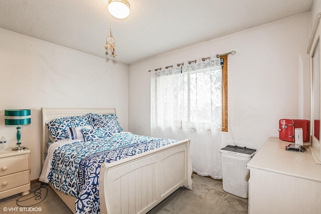 bedroom with a textured ceiling and light carpet