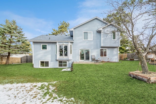 back of property with a lawn, a patio, and fence