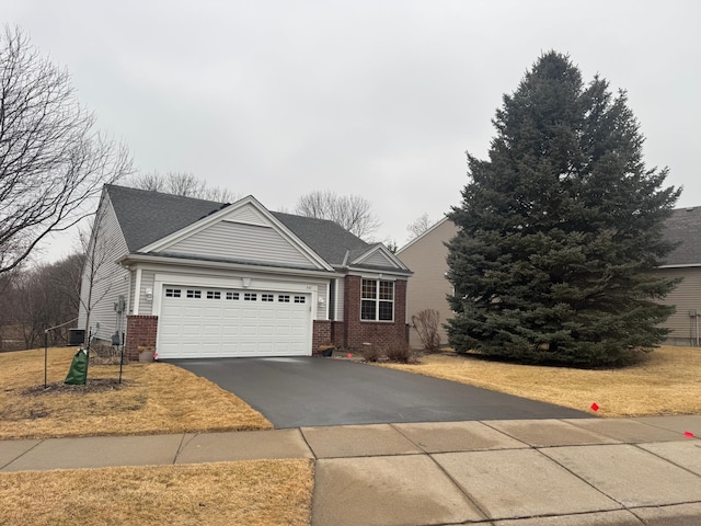 ranch-style house with driveway, an attached garage, and brick siding