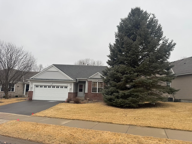 ranch-style house featuring a garage, aphalt driveway, a front yard, and brick siding