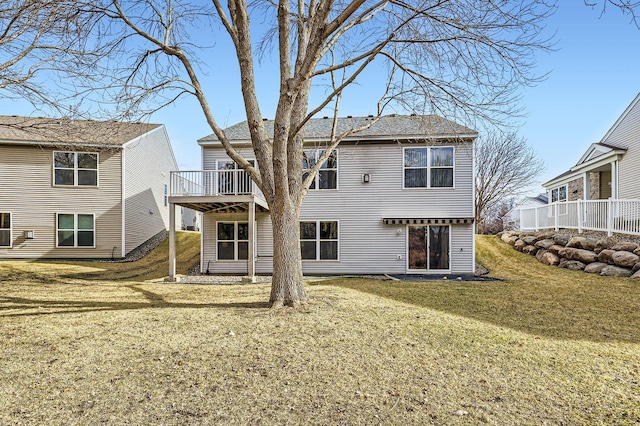rear view of house featuring a deck and a yard