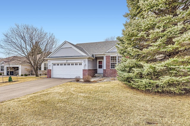 view of front facade featuring a front lawn, an attached garage, brick siding, and driveway