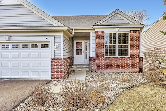view of front of home with brick siding, a shingled roof, and a garage
