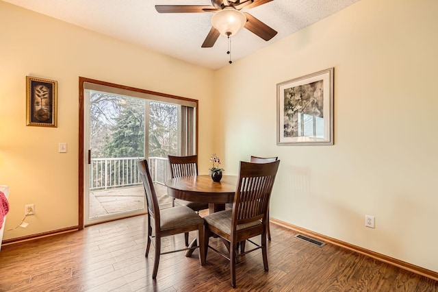 dining area featuring a ceiling fan, wood finished floors, visible vents, and baseboards