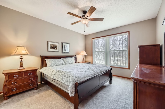 bedroom featuring carpet flooring, a textured ceiling, baseboards, and a ceiling fan