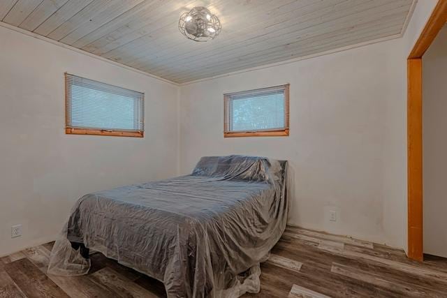 bedroom with wooden ceiling, multiple windows, and wood finished floors