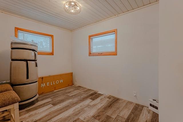 workout room featuring plenty of natural light, wood ceiling, and wood finished floors