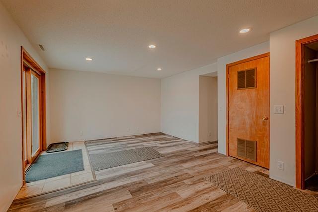 spare room with recessed lighting, wood finished floors, and visible vents