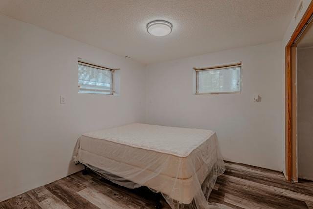 bedroom featuring a textured ceiling and wood finished floors