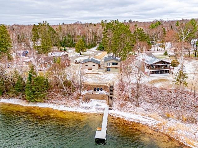 drone / aerial view with a forest view and a water view