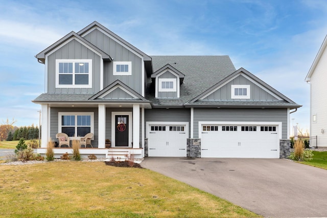 craftsman house featuring a front lawn, driveway, a porch, board and batten siding, and a shingled roof