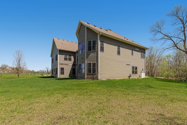 rear view of house featuring a lawn