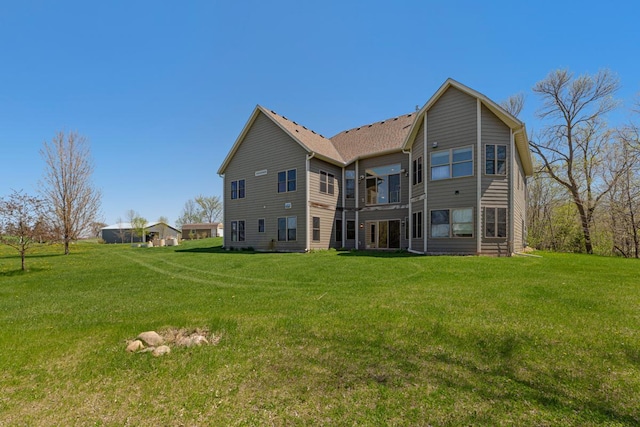 rear view of house featuring a lawn