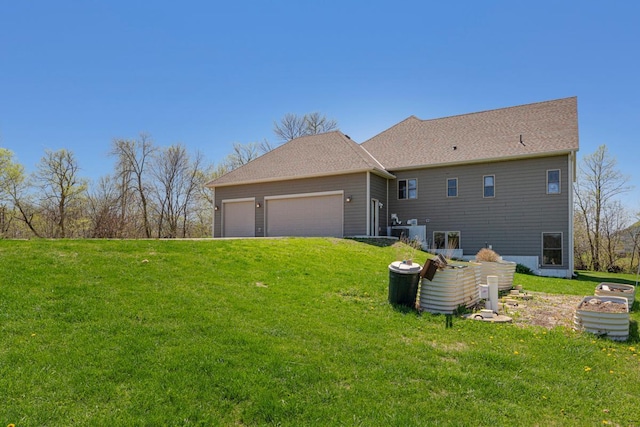 rear view of property featuring a lawn and an attached garage
