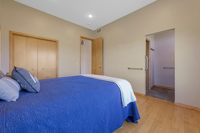 bedroom featuring light wood-type flooring, a closet, and baseboards