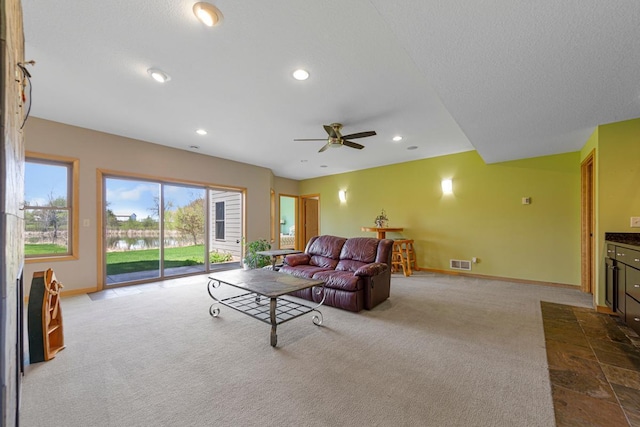 living room with baseboards, ceiling fan, dark carpet, recessed lighting, and a water view