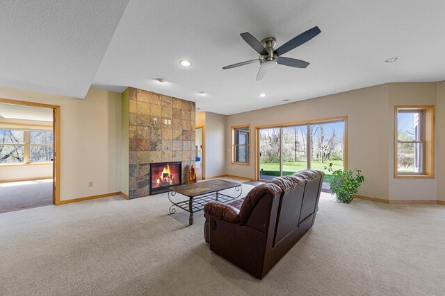 carpeted living area featuring baseboards, recessed lighting, a fireplace, and ceiling fan