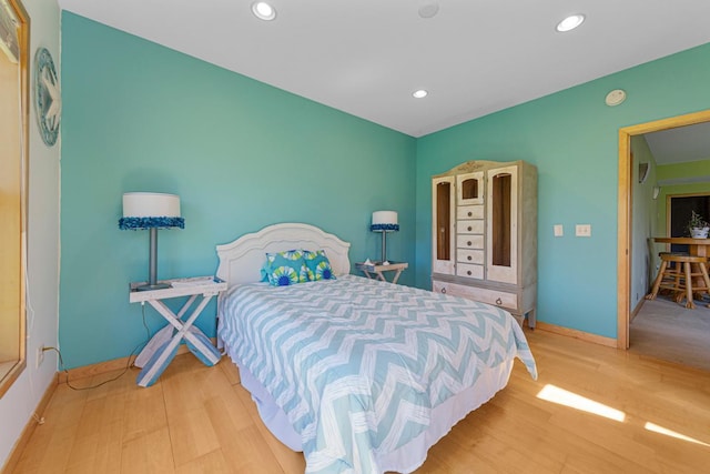 bedroom with light wood finished floors, recessed lighting, and baseboards