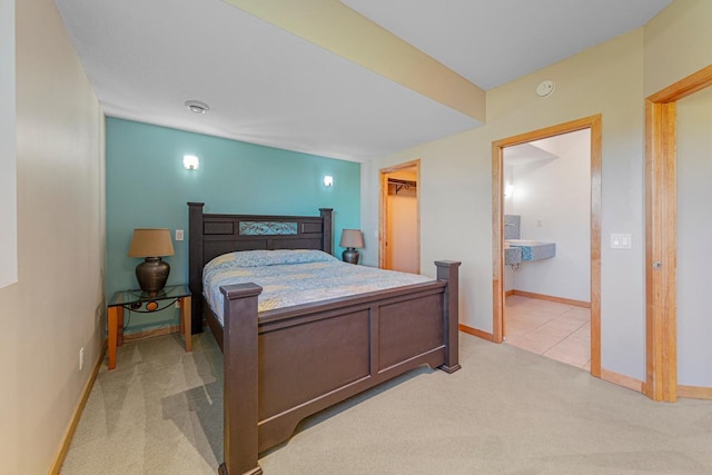 bedroom featuring light carpet, baseboards, and a spacious closet