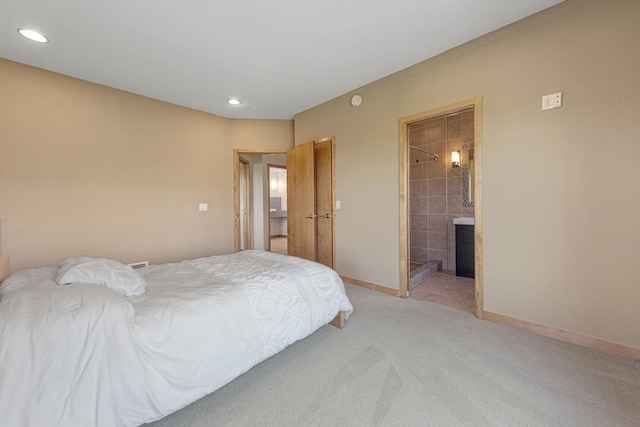 bedroom with light colored carpet, recessed lighting, connected bathroom, and baseboards