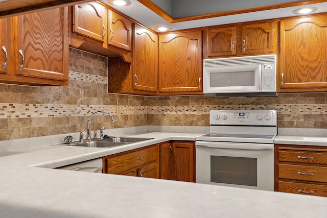 kitchen with white appliances, light countertops, a sink, and decorative backsplash