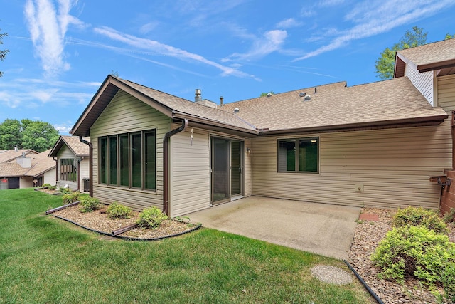 back of property featuring a yard, roof with shingles, and a patio