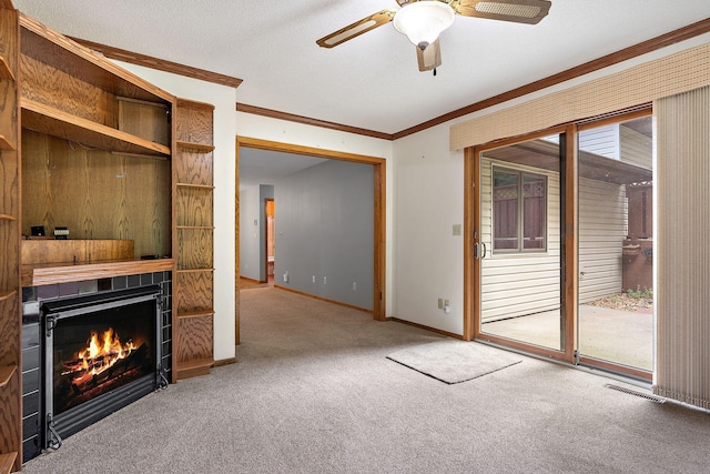 unfurnished living room with baseboards, visible vents, ornamental molding, carpet, and a fireplace