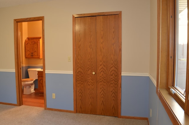 unfurnished bedroom with carpet floors, baseboards, and a closet