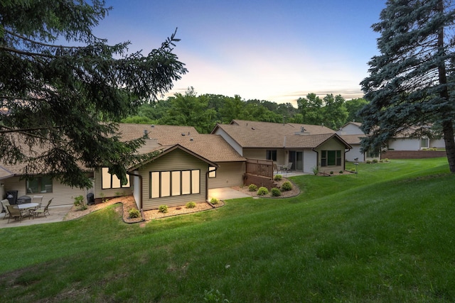 back of house featuring a patio area and a lawn