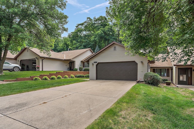 single story home featuring a garage, a front lawn, and concrete driveway