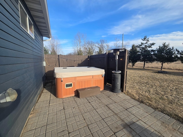 view of patio with fence and a hot tub