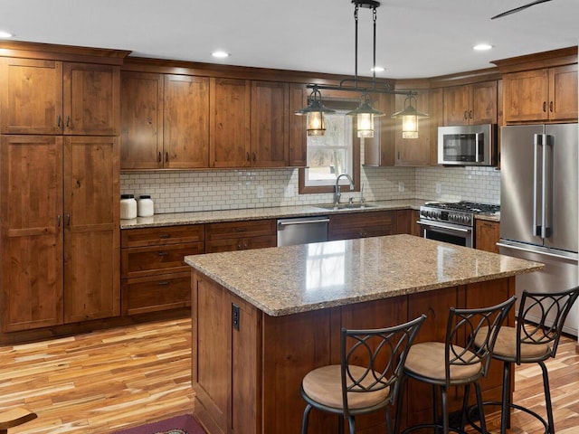 15015 Vermillion Cir NE, Andover, MN 55304 - kitchen with premium appliances, a sink, light wood-style floors, a kitchen island, and recessed lighting