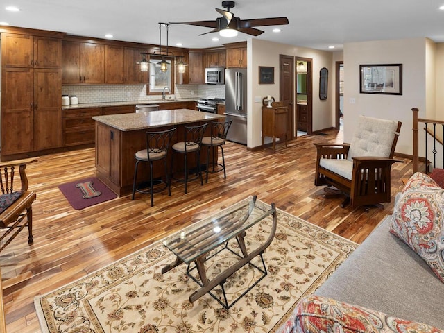 15015 Vermillion Cir NE, Andover, MN 55304 - living room with light wood finished floors, ceiling fan, recessed lighting, and baseboards