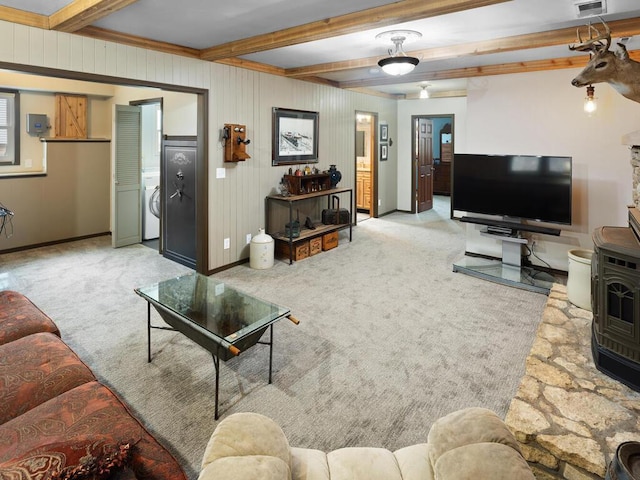 15015 Vermillion Cir NE, Andover, MN 55304 - carpeted living area featuring beam ceiling, washer / clothes dryer, baseboards, and a wood stove
