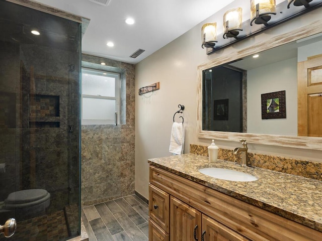 15015 Vermillion Cir NE, Andover, MN 55304 - bathroom featuring a tile shower, vanity, wood finish floors, recessed lighting, and baseboards