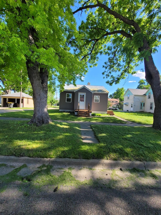 view of front of house featuring a front lawn and metal roof