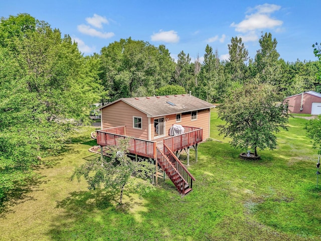 rear view of house with a forest view, a shingled roof, stairway, a wooden deck, and a lawn