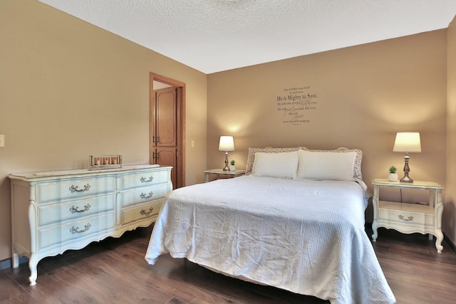 bedroom featuring a textured ceiling and dark wood-style floors